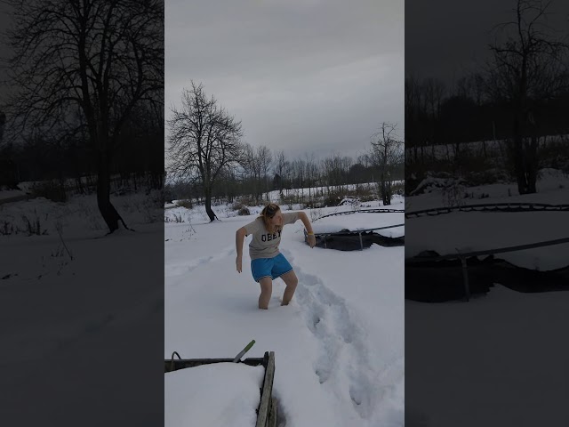 cousin jumps into the snow with t-shirt and shorts