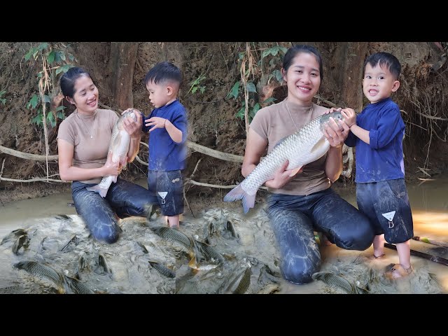 single mother harvesting fish in the stream, taking care of her children - single mother life