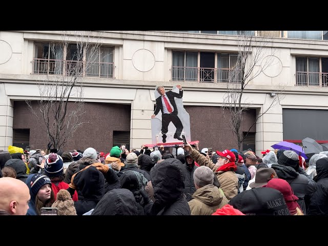 Trump Supporters Pass Cardboard Cutout of Trump Over Crowd Lined Up for Rally in DC