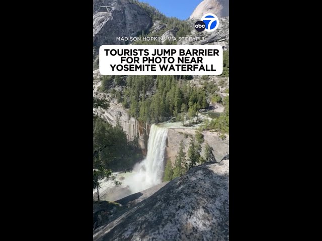 Tourists jump barrier for photo near Yosemite waterfall