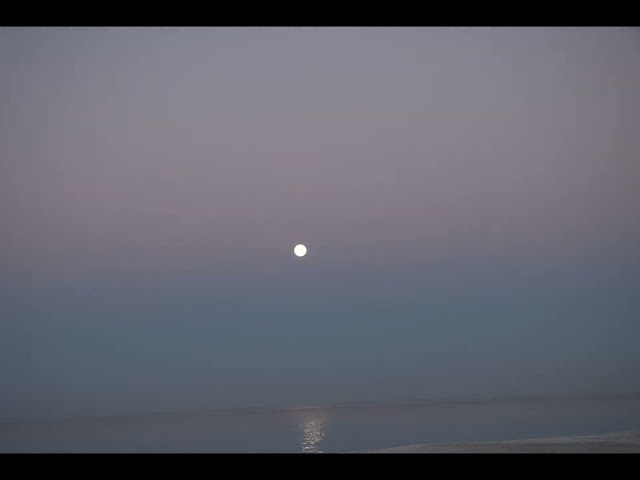 Full moon sets into the fog