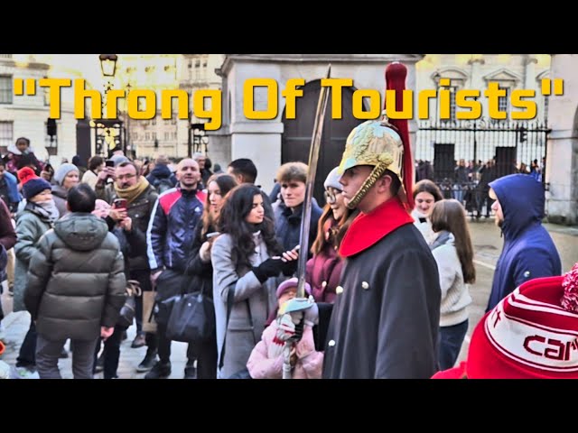 The King's Guard is surrounded by a throng of tourists and needs to turn around to reach the arch