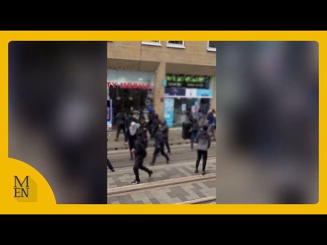 Moment masked mob storm Manchester city centre