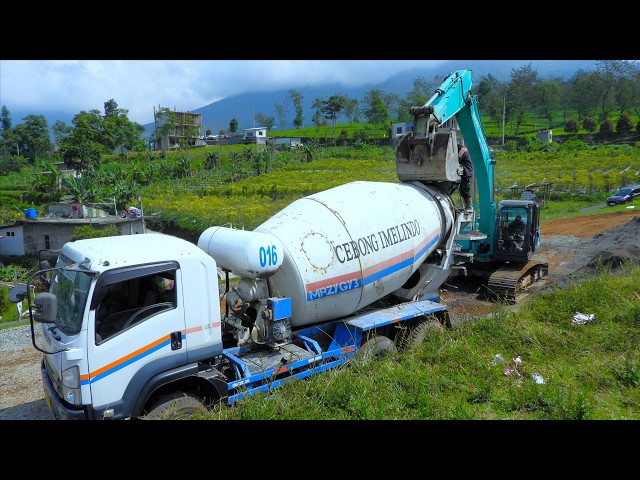 Excavator Helping Ready Mix Cement Truck Mixing Concrete