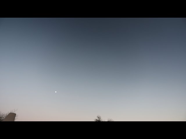 Moon rising as the sky grows dark time lapse