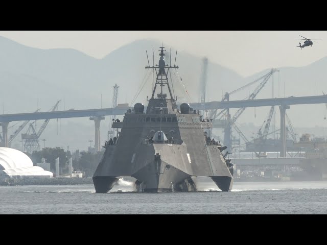 Unusual looking warship departs base as fighter jets and helicopters take off