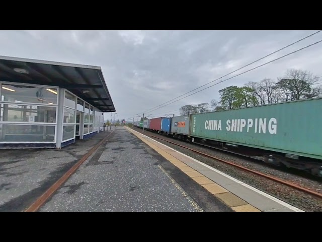 A freight train passes through Carstairs on 2021-05-15 at 0735 in VR180