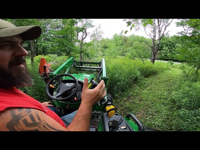 John Deere 4044M pushing trees over