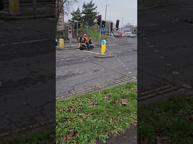 UK England's A Motorcycle on Full Gear Heading Towards Church Rd. Cars Vans.AMotorcycle in Traffic