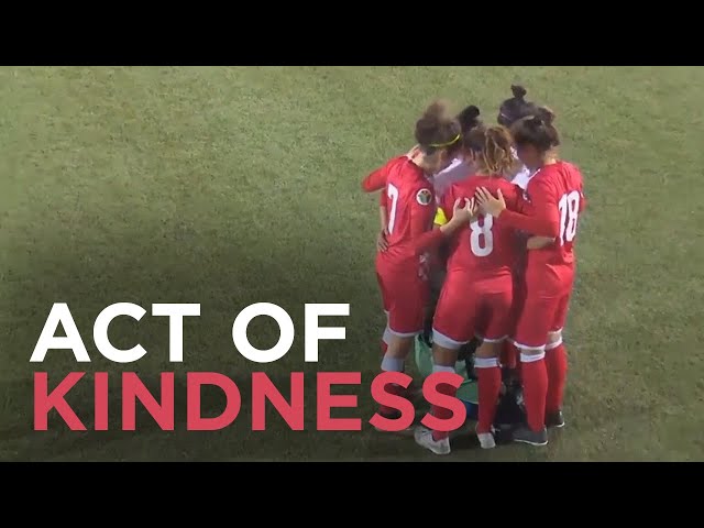 Opponents huddle around soccer player after hijab comes loose during match