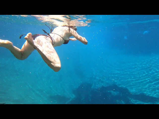 Bikini swimming over a hot geyser hole in the earth. Chemka Hot Springs, Tanzania.