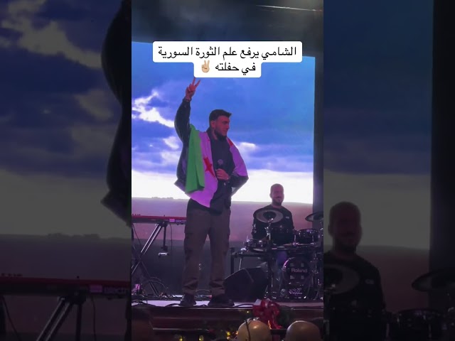 الشامي يرفع علم الثورة السورية على المسرح✌