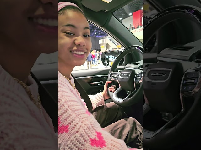 Peyton plays around with the stereo in a GMC Sierra EV @Chicago Auto Show