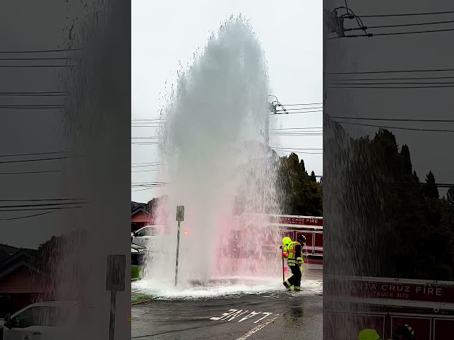 A firefighter and a water dept. employee shutting off water to a broken fire hydrant in Santa Cruz