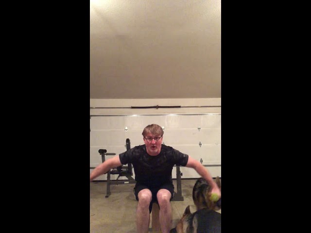 Seated Bent over lateral raises with two happy German shepherd's