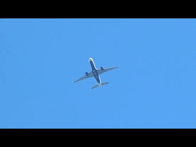 Avión azul volando cerquita