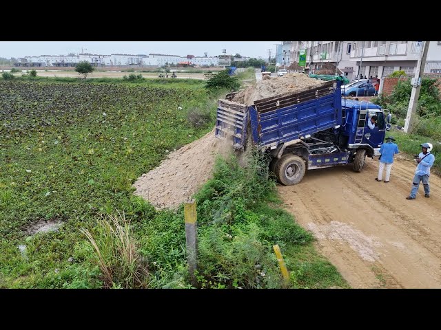 Technique.! Dump Trucks And D58E KOMATSU Dozer filling Flooded land Next to the road.