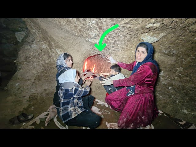 A nomadic mother builds a fireplace for her children inside a cave