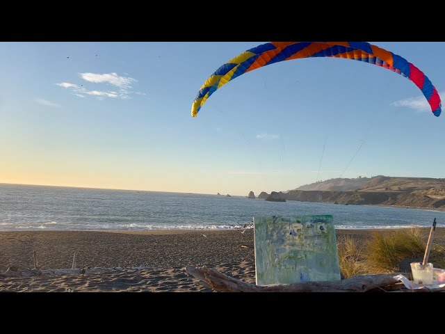 a paraglider flies over the next ABC Painting Challenge