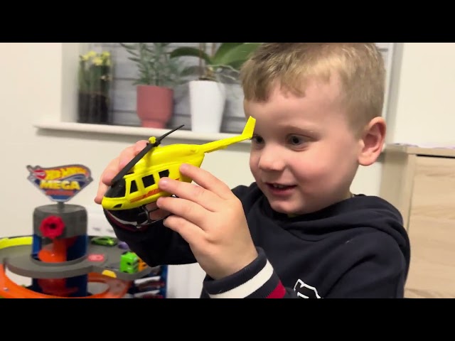 Martynka and Konradek are playing with toy cars and a mega Hot Wheels garage.