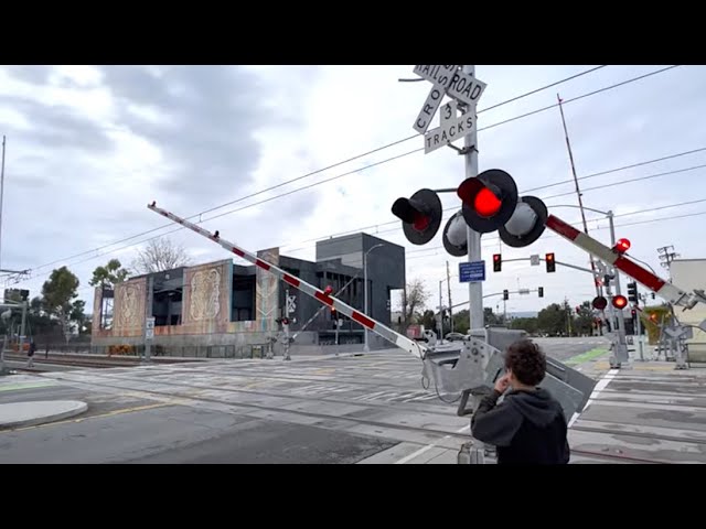 Metro Trains pass railroad crossing on Stewart street