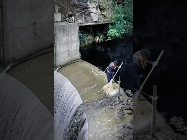 Clearing trash above the flowing water dam- Good tools and machinery in daily work